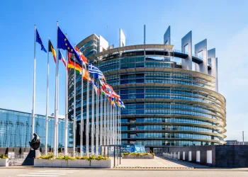 Exterior of European Parliament building with Member State flags to the left.
