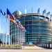 Exterior of European Parliament building with Member State flags to the left.