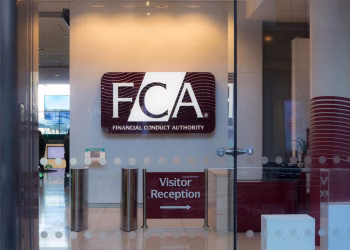 Entrance to the Financial Conduct Authority (FCA) office, showing a large FCA logo on the wall and a sign pointing to Visitor Reception, viewed through glass doors.