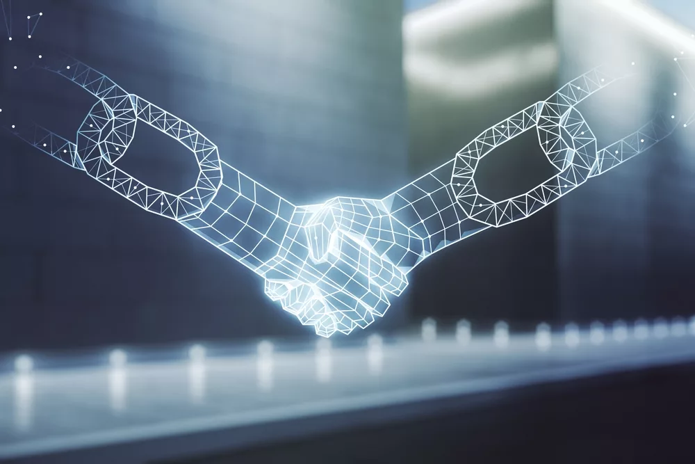 Digital picture of two robotic-looking hands shaking to illustrate an article about the consensus mechanism in blockchain.