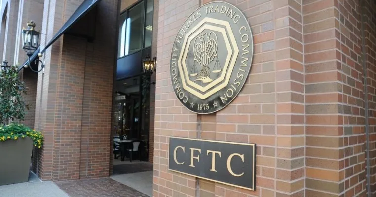 The exterior of a brick building displays the Commodity Futures Trading Commission (CFTC) seal and a sign with the acronym CFTC near the entrance.