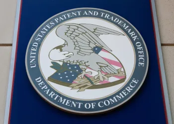 The official seal of the United States Patent and Trademark Office, featuring a bald eagle with a flag shield holding a branch and arrows, surrounded by a blue ring with the agency’s name and “Department of Commerce.”.