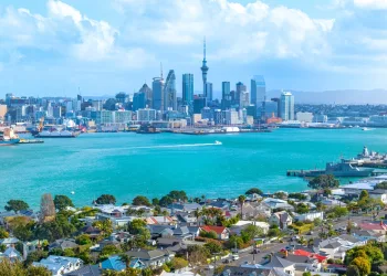 Scenic image of Auckland showing the CBD in the background and water in front, used to illustrate an article about crypto usage in New Zealand.